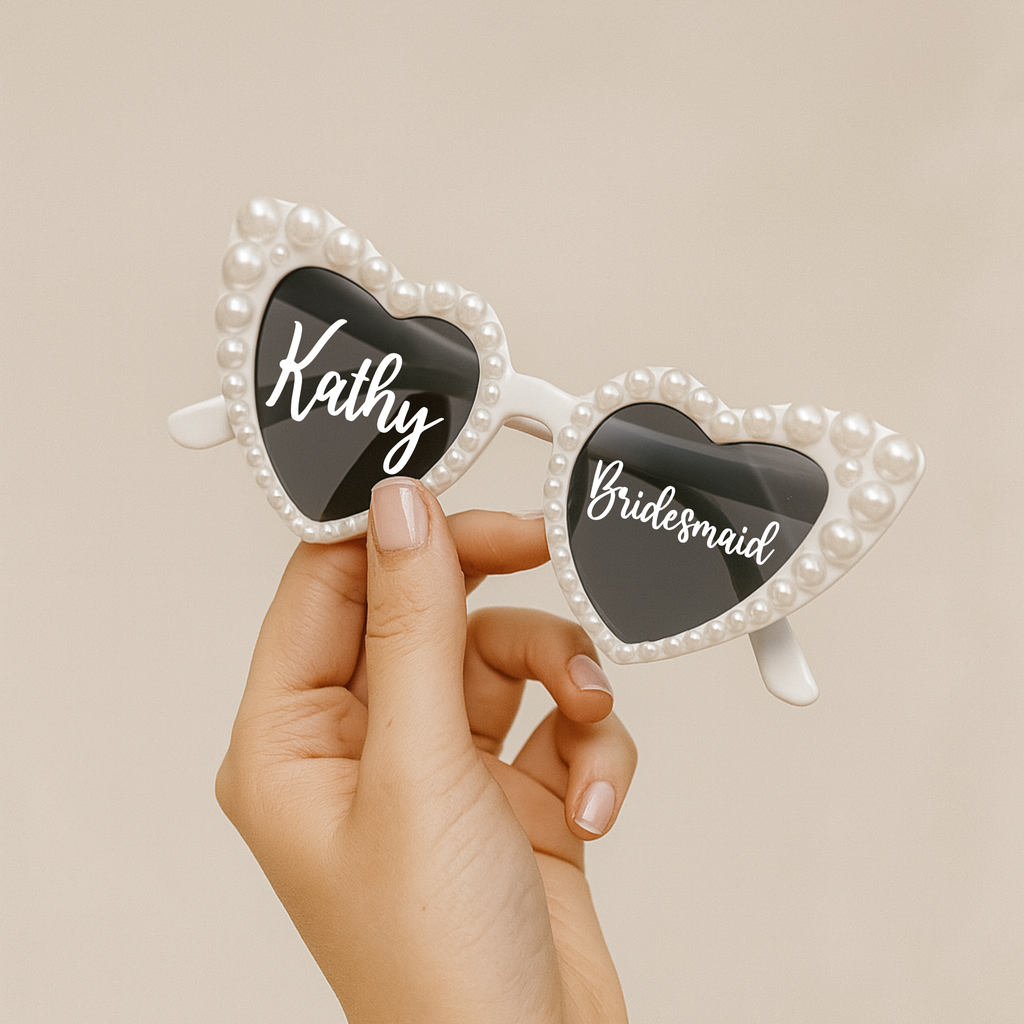 Gafas de sol corazón con perlas personalizadas para boda sostenidas en mano - detalle invitados