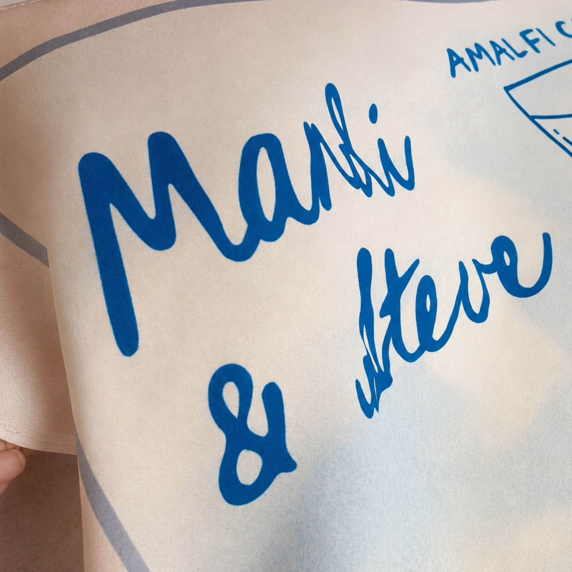 Detalle nombres novios en letra manuscrita azul sobre pañuelo boda personalizado