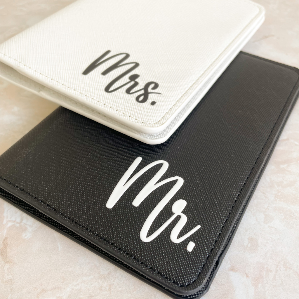 Detalle de porta pasaportes Mr y Mrs apilados en cuero negro y blanco - set viaje pareja